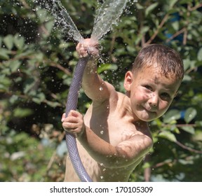 Boy Squirting Water From A Hose