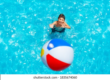 Boy Stand In Swimming Pool Throw Inflatable Ball View From Above