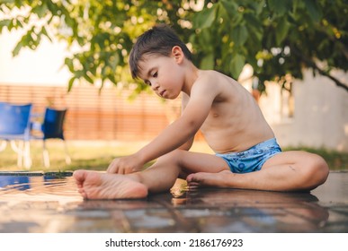 Boy Standing In The Garden Yard, Splashing Himself With Water On A Hot Summer Afternoon. Summertime Holiday. Summer Holidays. Summer Nature.