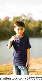 The boy is standing at the lawn.