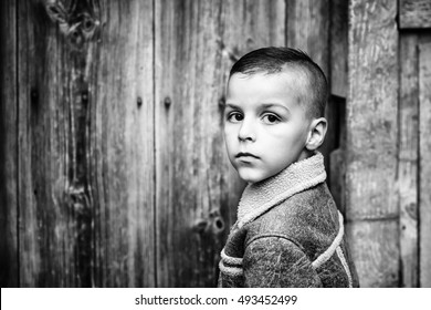 Boy Standing Next To A Wooden Door Black And White Photography