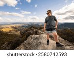 Boy standing on rock at Hassans Walls Lookout watching valley below