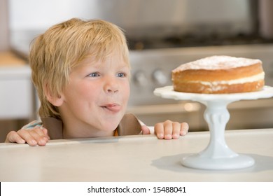 Boy Staring Longingly At Cake At Home Licking Lips