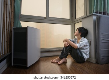 Boy staying home near air purifier on extremely polluted day