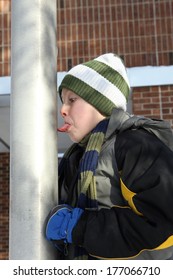 Boy sticking his tongue on a flag pole