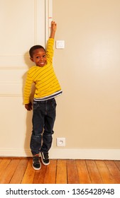 Boy Stretch His Hand To Measure Height On Door