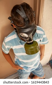 Boy In Striped Shirt Wearing Gas Mask At An Apartment Complex. Image Can Be Used For Coronavirus,Covid-19,Pandemic,air Pollution, Second Hand Smoke ,or Asthma