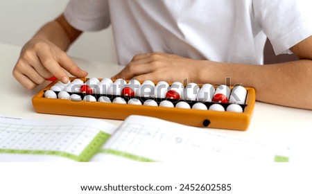 boy student doing mental arithmetic on the abacus