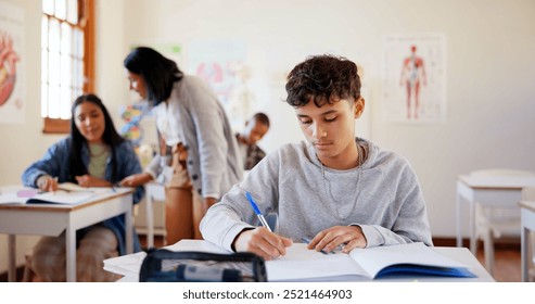 Boy, student and writing with book in classroom for education, learning or exam at school. Young, male person or teenager with moderator, educator or notebook for test, assignment or assessment - Powered by Shutterstock