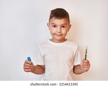 The boy successfully sharpened the pencil with a sharpener. Preparation of school supplies.