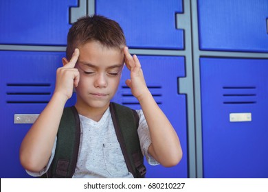 Boy suffering from headache against lockers at school - Powered by Shutterstock