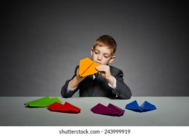 Boy In Suit Making Yellow Paper Plane