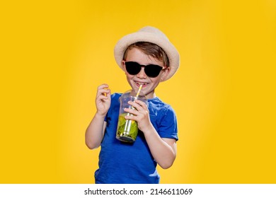 Boy In Summer Outfit Wearing Sunglasses And Enjoying While Drinking A Mojito Cocktail. Posing On The Yellow Background