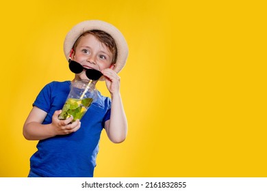 Boy In Summer Outfit Wearing Sunglasses And Enjoying While Drinking A Mojito Cocktail. Posing On The Yellow Background