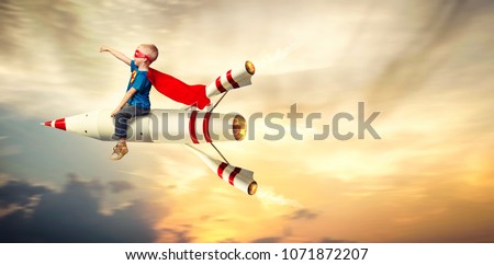 Boy in superhero costume fly on a rocket and show super abilities.