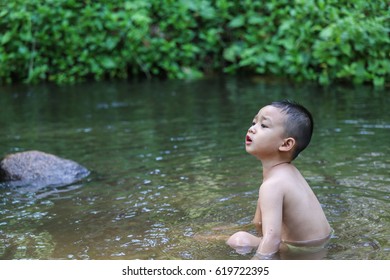 Boy swim  in the stream, Northern Thailand - Shutterstock ID 619722395