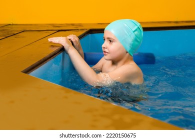 Boy Swimming In Indoor Pool Having Fun During Swim Class