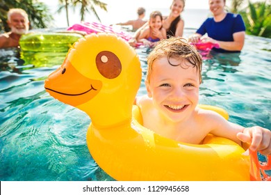 Boy Swimming In A Pool With Family