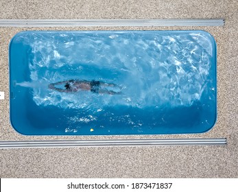 The Boy Swims In The Pool. The Athlete Trains In Countercurrent. Wellness Resort. Aerial View.
