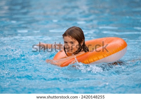 Boy swims in pool with float. Swimming, summer vacation. Child swim in pool on inflatable ring. Kid with inflatable ring in swimming pool. Summer vacation. Child swiming. Kid floating in sea water.