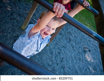 Boy Swinging On Monkey Bars