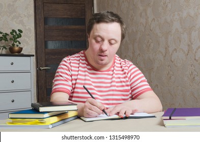 Boy with syndrome down diligently writing,home interior