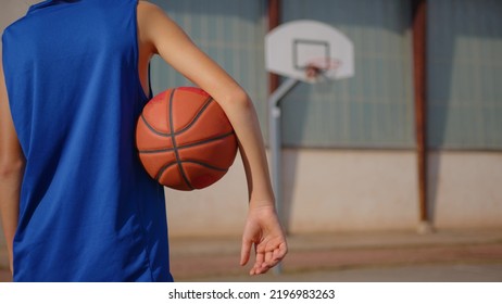 Boy taking break after basketball game and drink fresh water from bottle. Sport concept. Rehydration after basketball game. Basketball player drinking water. Boy in a blue basketball uniform - Powered by Shutterstock