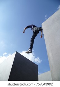 Boy Taking Giant Leap Forward Between Two Blocks