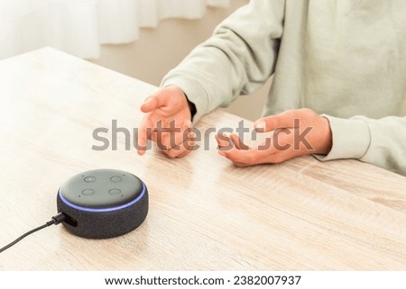 A boy talking to a smart speaker.