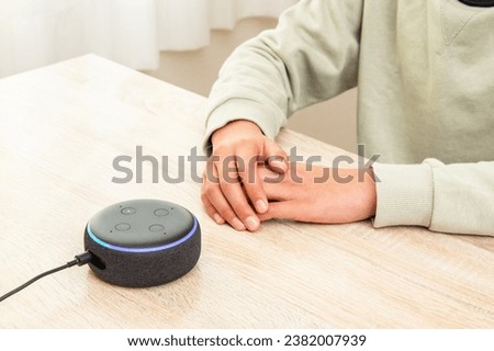 A boy talking to a smart speaker.