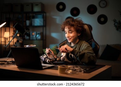 Boy Talks To Friend Via Webcam On Laptop, Shows How He Learned To Solder Electronics, Brags About Robot Project, Explains Connection Of Cables For Remote Control Of Toy