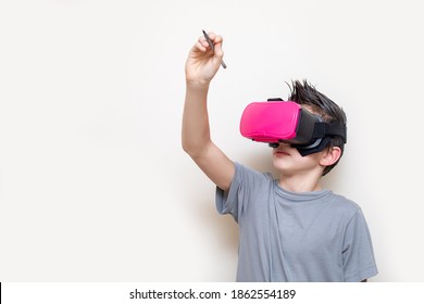 Boy Teenager In Glasses Of Virtual Reality Simulator Receives Online Education Or Plays, Writes On The Virtual Space. Modern Education With The Help Of Digital Technologies. Photo Close-up