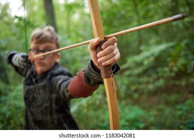 boy teenager has training, shoots a wooden bow in the forest - Powered by Shutterstock