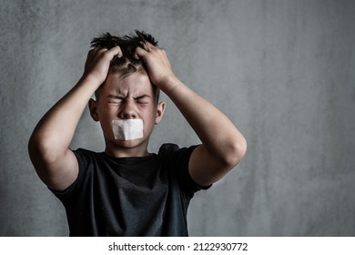 Boy teenager with a sealed mouth yells while clutching his hair with his hands. Problems of emotional detachment and isolation in adolescent children - Shutterstock ID 2122930772