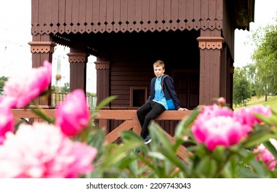 Boy Teenager Sitting On A Wooden Veranda At The Station