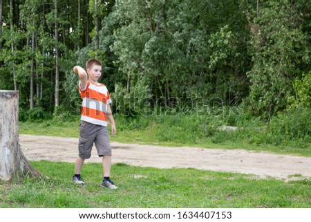 Boy throwing a knife, exercing in forest.