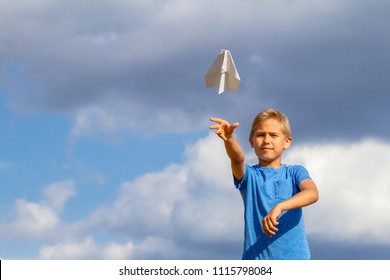 Boy Throwing Paper Plane Against Blue Sky