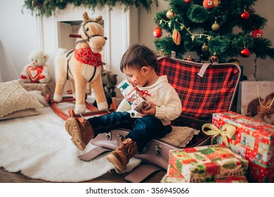 Boy With Toy Horse Near Christmas Tree