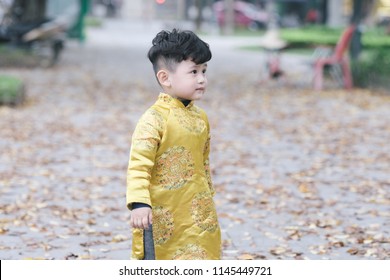 The boy in traditional Vietnamese costume plays along the road with beautiful trees at sunset in Hanoi, Vietnam. date 04/03/2018