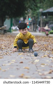 The boy in traditional Vietnamese costume plays along the road with beautiful trees at sunset in Hanoi, Vietnam. date 04/03/2018
