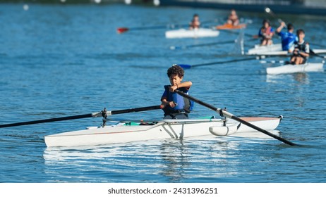 Boy training rowing on a lake near his home with his classmates, focus and background out of focus. - Powered by Shutterstock