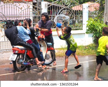 Boy try to powder girl and each one is splashing bucket of water in Songkran festival in Thailand on April 13, 2018. Many boy and girl playing water at the street in their local.