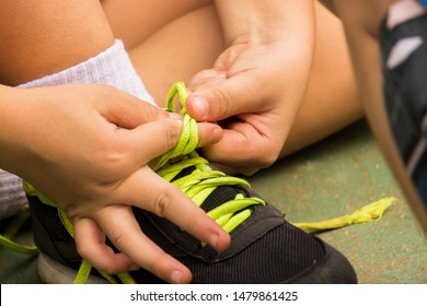 The Boy Is Trying To Tie The Shoe By Himself.