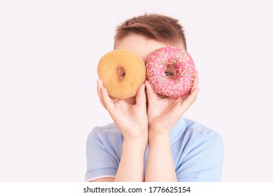Boy with two doughnut. place for text. Modern concept without a face. Male kid play with food. Sweet desert party. Grey isolated background. Horizontal. Unhealthy tasty round cake - Shutterstock ID 1776625154