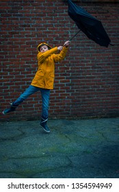 Boy With Umbrella Blown Away By The Storm