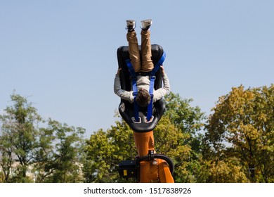 boy upside down on a carousel in an amusement park