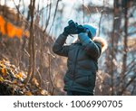 Boy using digital camera taking photo in the nature, hobbies concept 