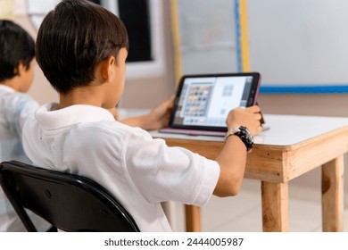 boy using digital device in school classroom.