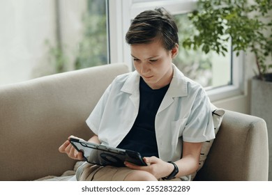 Boy Using Digital Tablet At Home