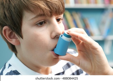 Boy Using Inhaler To Treat Asthma Attack